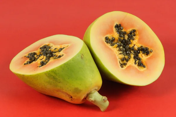 Papaya fruit sliced on half isolated on a red background. — Stock Photo, Image