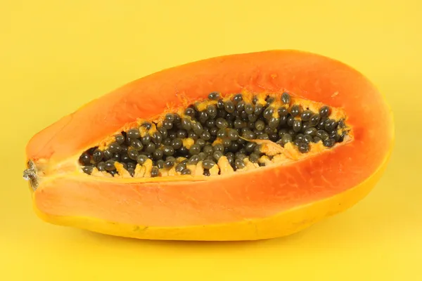 Papaya fruit sliced on half isolated on yellow background. — Stock Photo, Image