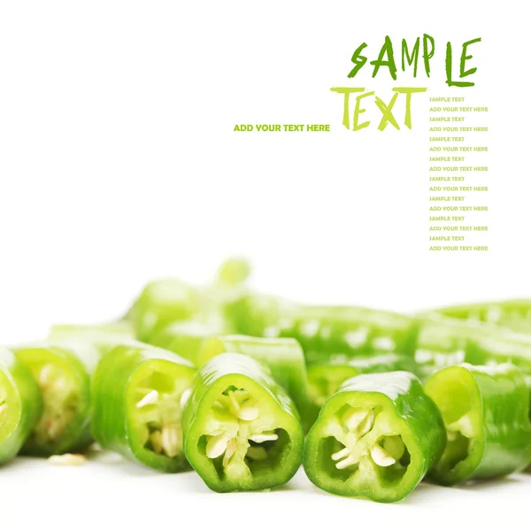 Green chili pepper cut in pieces on a white background — Stock Photo, Image