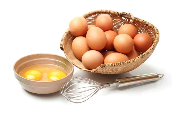 Wire whisk and brown eggs — Stock Photo, Image