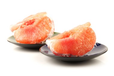 Pomelo pieces on plates clipart