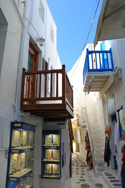 Narrow cozy street of the island of Mykonos with colorful wooden balconies early evening — Stock Photo, Image
