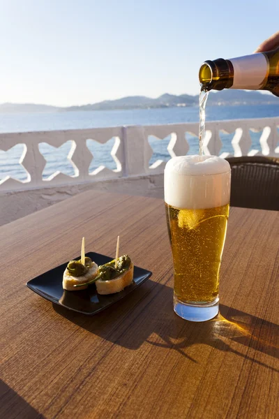 Verser de la bière dans un verre près de la mer . — Photo