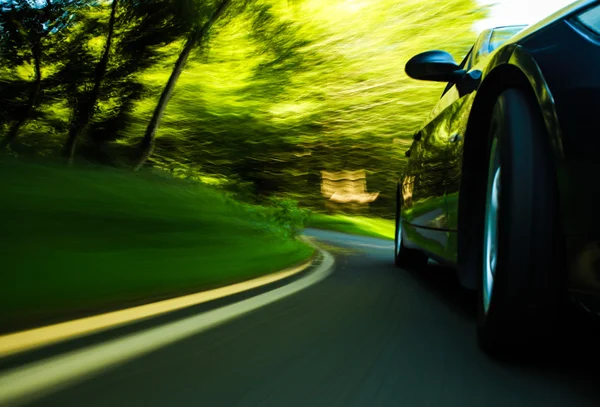 siyah lüks sedan hızlı sürüş görünümü.