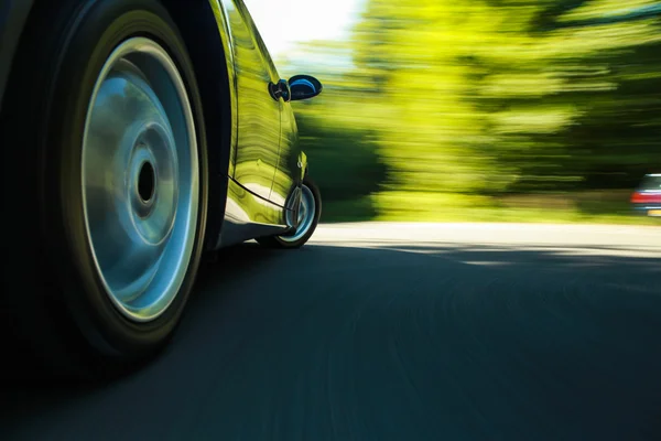 siyah lüks sedan hızlı sürüş görünümü.