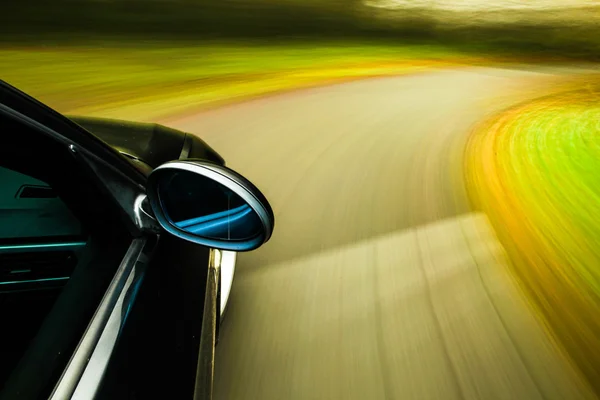 siyah lüks sedan hızlı sürüş görünümü.