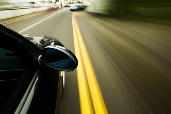 Vista di nero berlina di lusso alla guida veloce . — Foto Stock