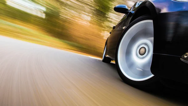 siyah lüks sedan hızlı sürüş görünümü.