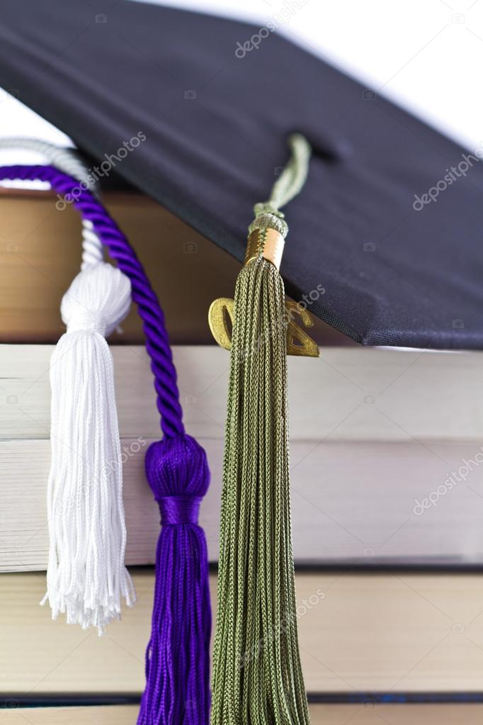 Cap and cords on books, achievement and education symbols