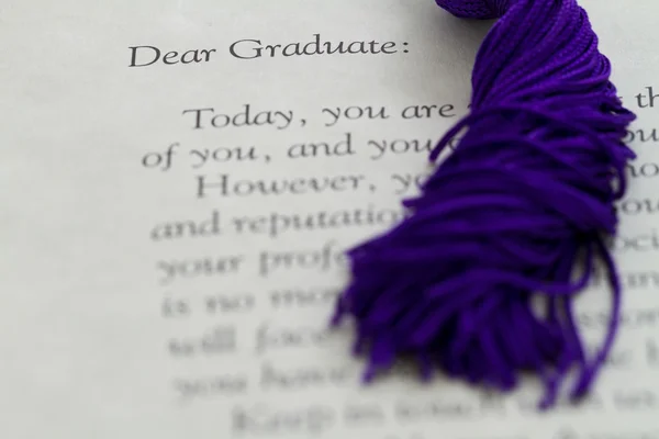 Cordones de borla apoyados en la parte superior del papeleo de graduación — Foto de Stock