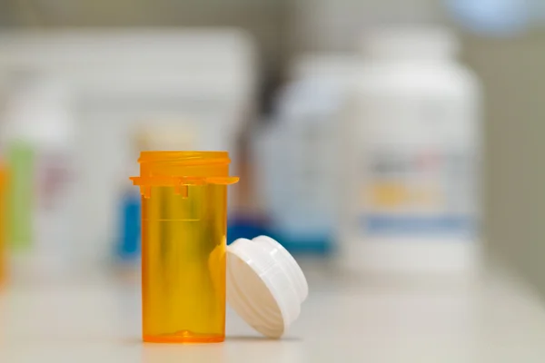 Pharmacy vial ready to be filled, counting tray in the background — Stock Photo, Image