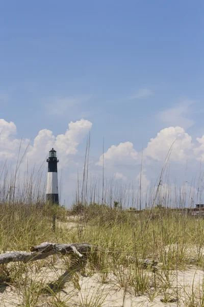 Sandy beach with the lighthouse, off in the distance, copy space. — Stock Photo, Image
