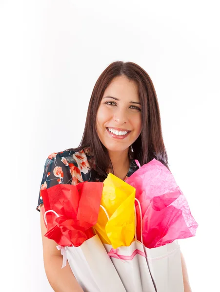 Joven mujer sosteniendo bolsas de regalo en sus brazos, aisladas en blanco Fotos De Stock Sin Royalties Gratis