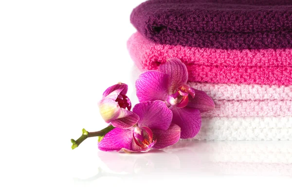 renkli banyo havlusu ve mor orkide çiçekleri yığını