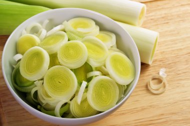 taze bütün ve ahşap ekmek tahtası dilimlenmiş pırasa