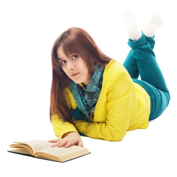 Portrait of a teenager lying on the floor reading book isolated on white — Stock Photo, Image