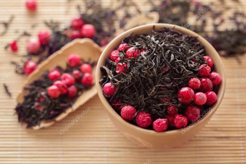 Black tea leaves with dry cranberries in a bowl — Stock Photo