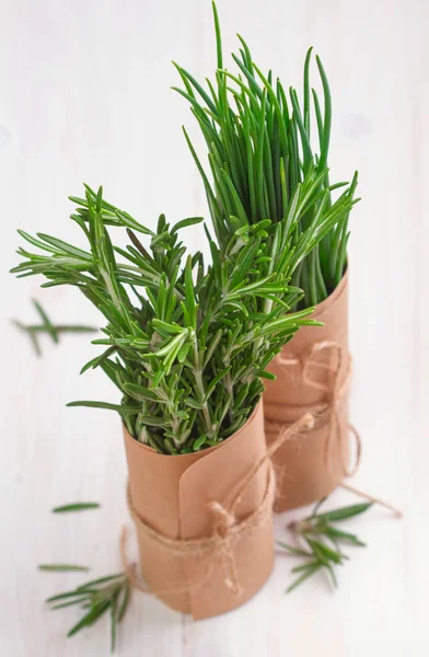 Bunch of fresh rosemary and chives on wooden table — Stock Photo, Image