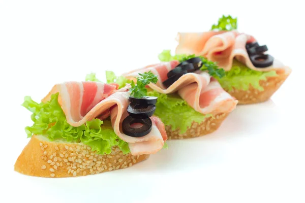 Appetizers - bread slices with bacon and salad — Stock Photo, Image