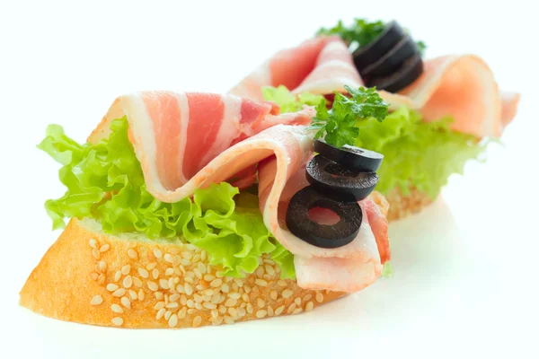 Vorspeisen - Brotscheiben mit Speck und Salat — Stockfoto