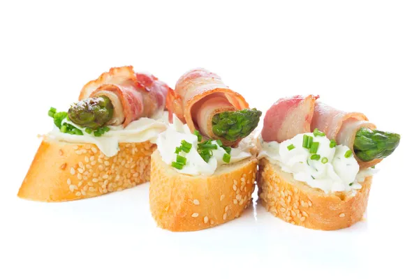 Appetizers - bread slices with bacon, asparagus and soft cheese — Stock Photo, Image