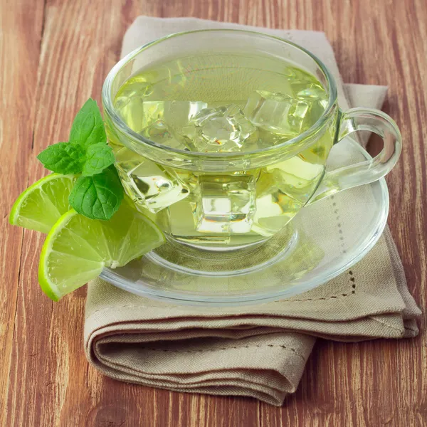 Cold green tea with ice cubes, lime sliced and mint leaves — Stock Photo, Image