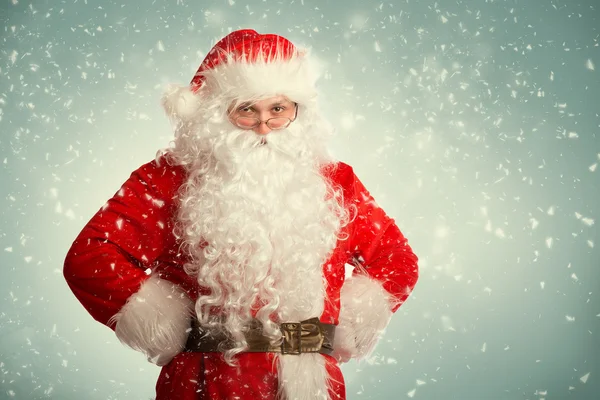 Santa claus staande in een sneeuw met zijn handen op de heupen — Stockfoto