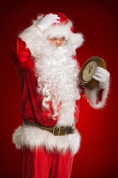 Babbo Natale in possesso di un orologio che mostra diversi minuti a mezzanotte — Foto Stock