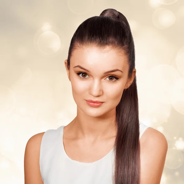 genç kadın, sağlıklı parlak kahverengi saçları at kuyruğu koymak.