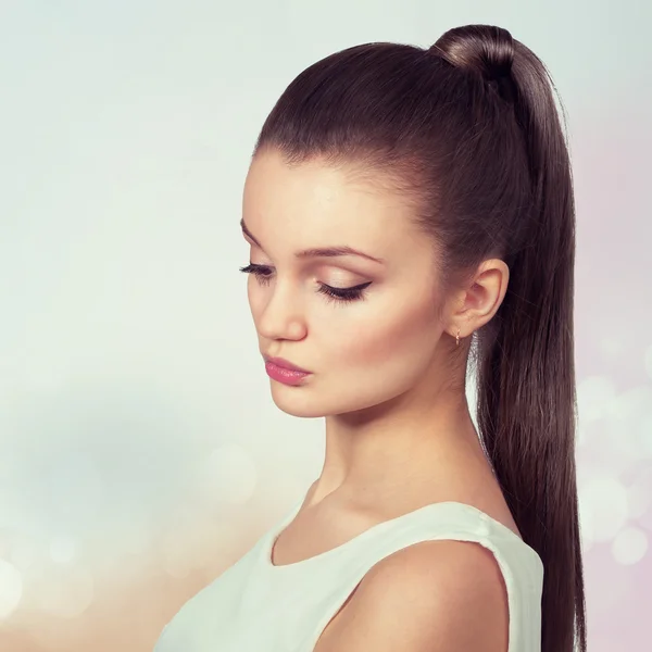 Young female with healthy shining brown hairs put in pony tail. — Stock Photo, Image