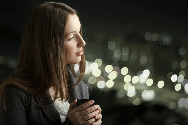 bir kupa kahve tutan genç güzel kadın