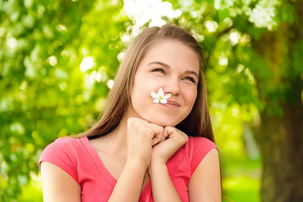 Jovem mulher feliz ao ar livre segurando na flor da árvore da maçã — Fotografia de Stock
