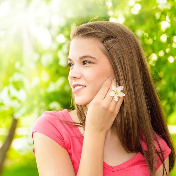 Junge glückliche Frau im Freien hält sich an Apfelbaumblüte fest — Stockfoto