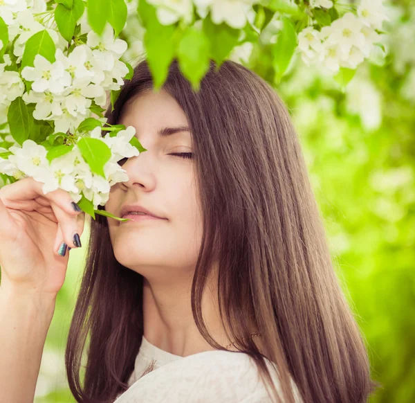 Prachtige lente brunette meisje in de bloeiende tuin — Stockfoto