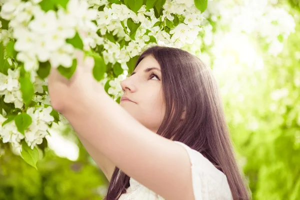 Vacker vår brunett tjej i blommande trädgård — Stockfoto