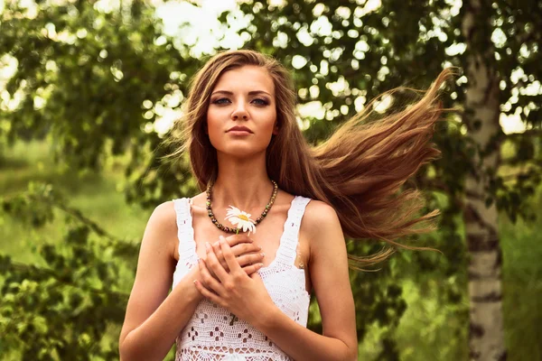 Happy young beautiful girl standing in the wind outdoor, holding — Stock Photo, Image