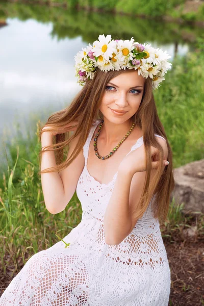 Leuke jonge vrouw met circlet van Kamille op de riverside — Stockfoto