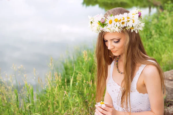 Leuke jonge vrouw met circlet van Kamille op de riverside — Stockfoto