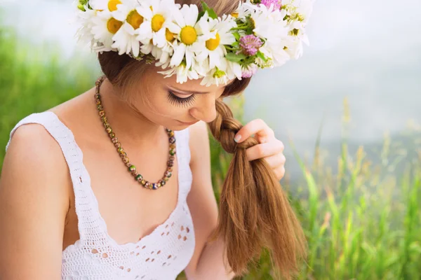 Söt ung kvinna med diadem av camomile fläta hennes hår på t — Stockfoto