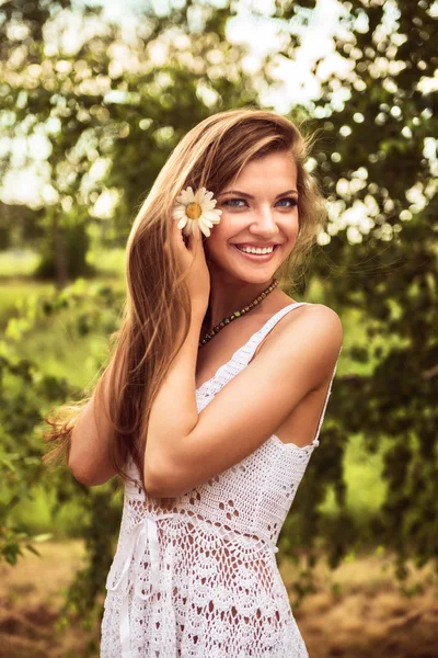 Jovem bela mulher ao ar livre em um bétula com flores de margarida — Fotografia de Stock