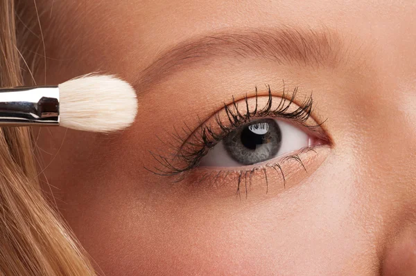 Mujer aplicando sombra de ojos — Foto de Stock