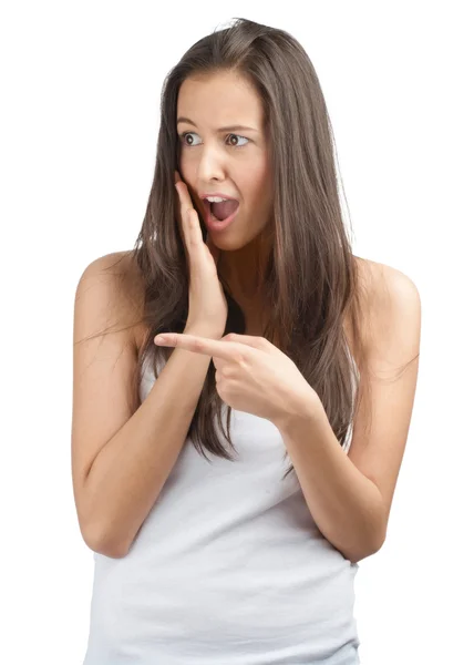 Young woman pointing and looking surprised — Stock Photo, Image