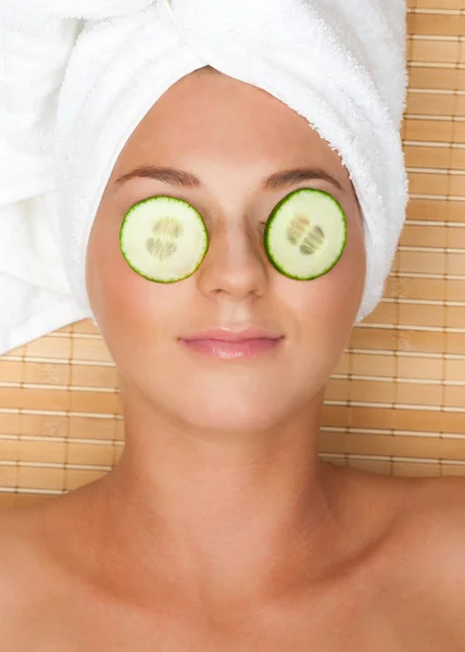 Vrouw met gezichts masker van komkommer — Stockfoto