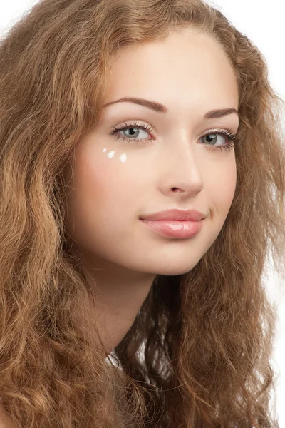 Vrouw met druppels moisturizer crème op haar gezicht — Stockfoto