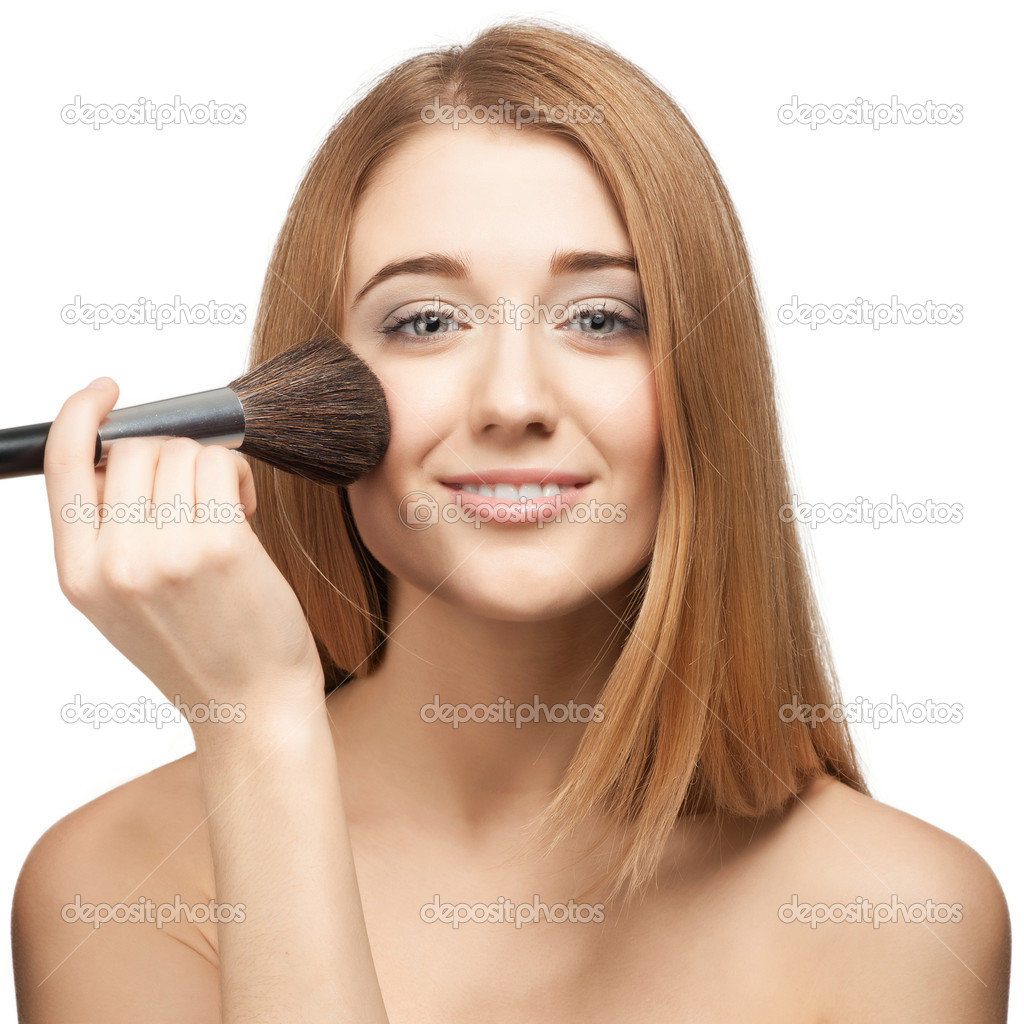 Pretty young woman with brush for makeup