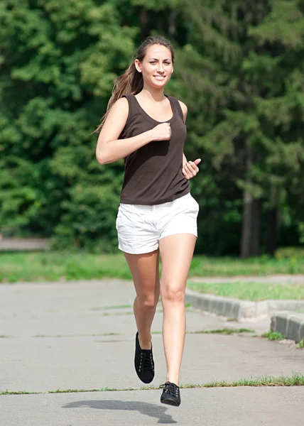 Jeune femme courant dans le parc — Photo