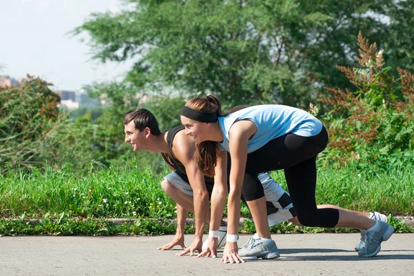 Hombre y mujer listos para empezar a correr — Foto de Stock