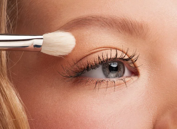 Mujer aplicando sombra de ojos — Foto de Stock