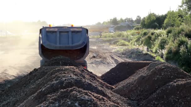 A dump truck dumps a pile of soil in mountains of soil — Stock Video
