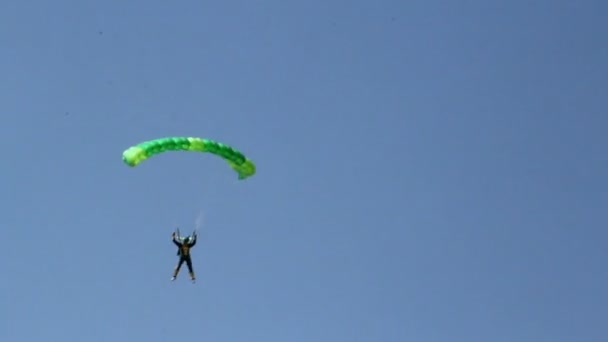 Een persoon met een groene parachute — Stockvideo